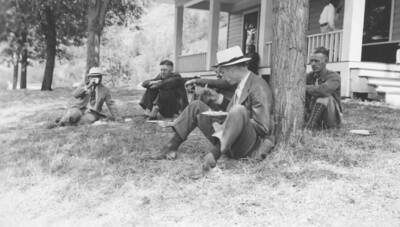 Photo caption: 'Our guest speakers from the University of Idaho,. They enjoy the lunch prepared by the Indian women.' This image is part of a report regarding farm organizations among tribes in Northern Idaho and the CCC-Indian Division.