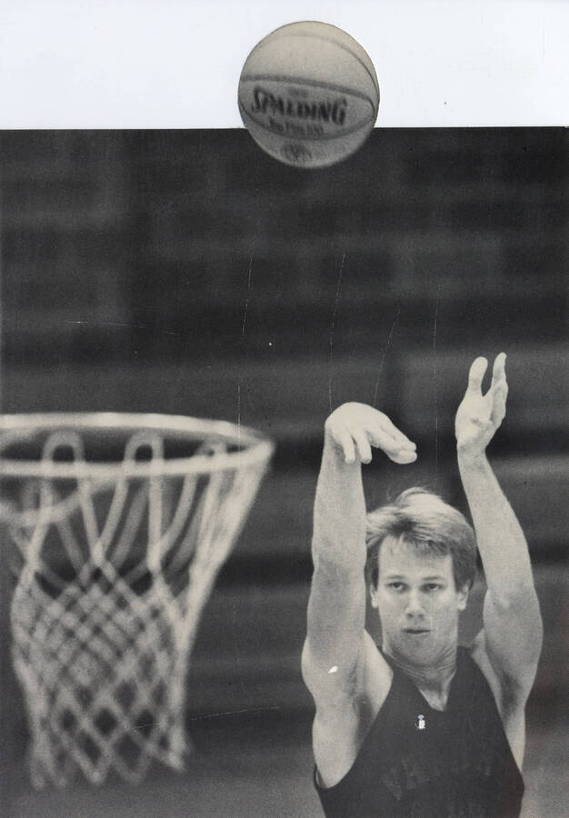 Mark Hiske shooting a basketball. The physical photograph has been cut-out around the basketball.