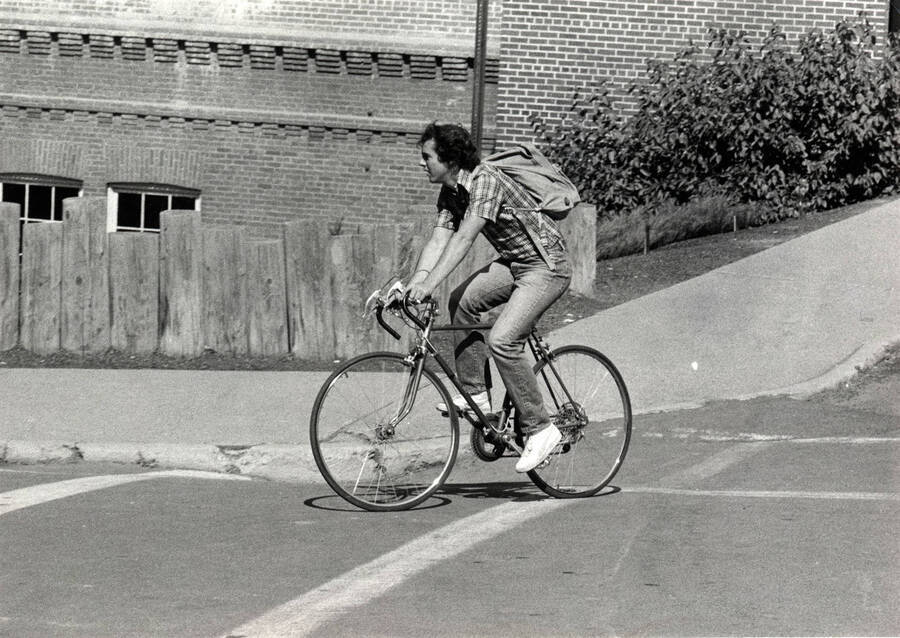 Student riding bicycle on campus.