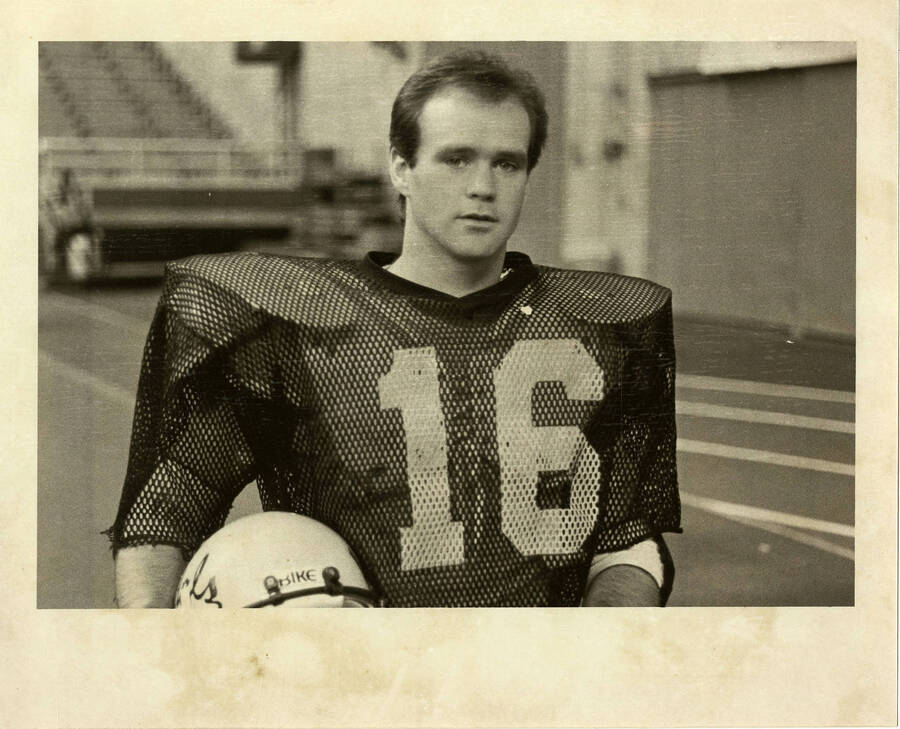 Idaho football player, wearing jersey number 16, holding his helmet.