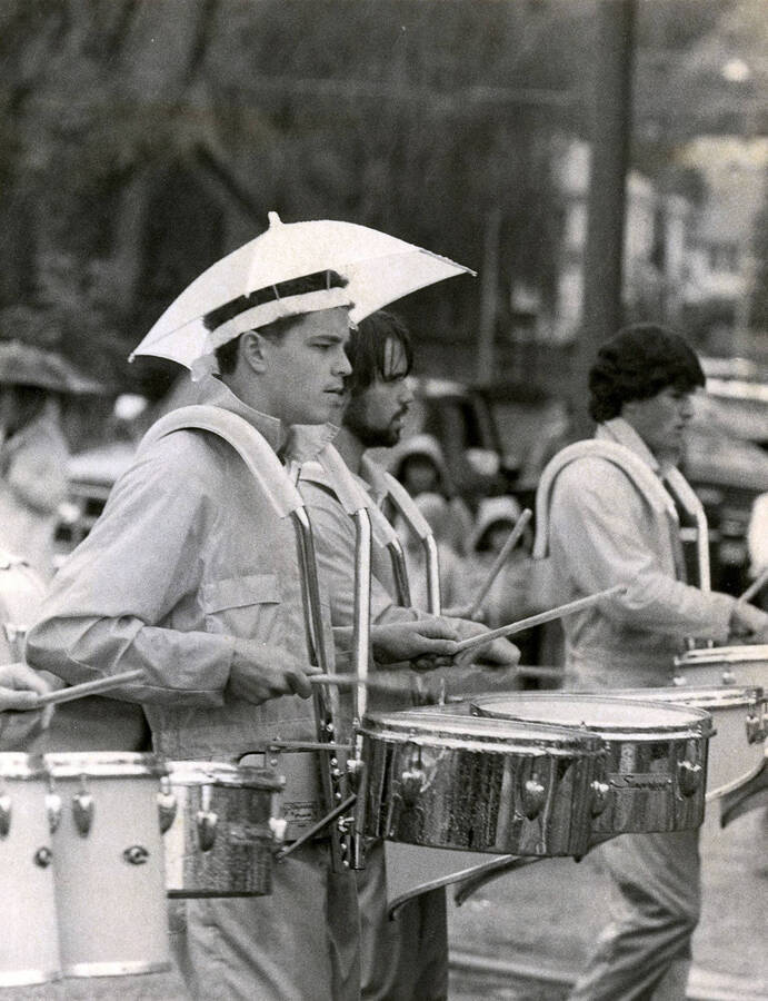 The U of I Marching Band's percussionists. One of the student musicians is wearing an umbrella hat.