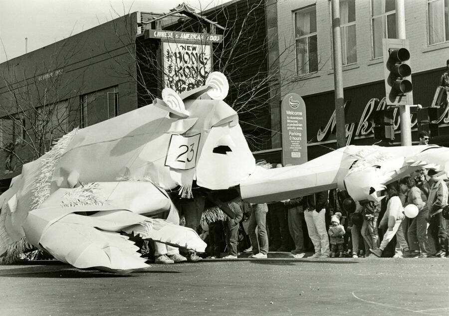 A white lobster parade float with the number 23 on its side moves through a parade on Main Street, on the north side of the 3rd Street and Main Street intersection.