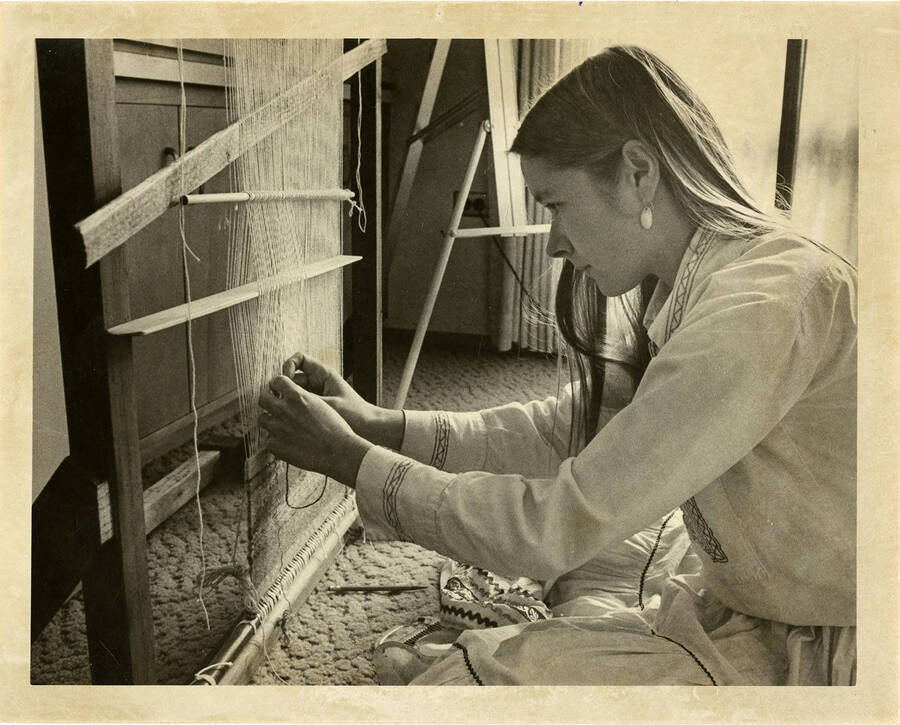 Female student weaving thread.