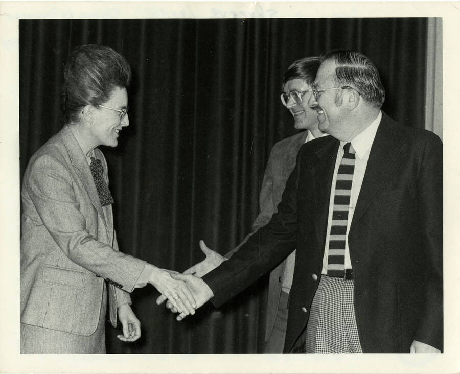 Jean'ne Shreeve (left), Duane Le Tourneau (right foreground) shaking hands.