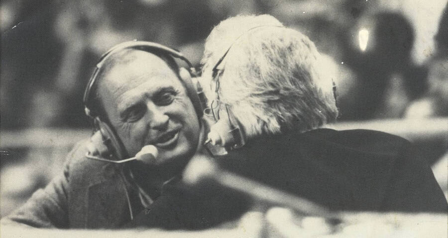 Legendary Vandals sports broadcaster Bob Curtis (right, facing away) talking with men's basketball coach Don Monson after a game, likely in 1981 or 1982.