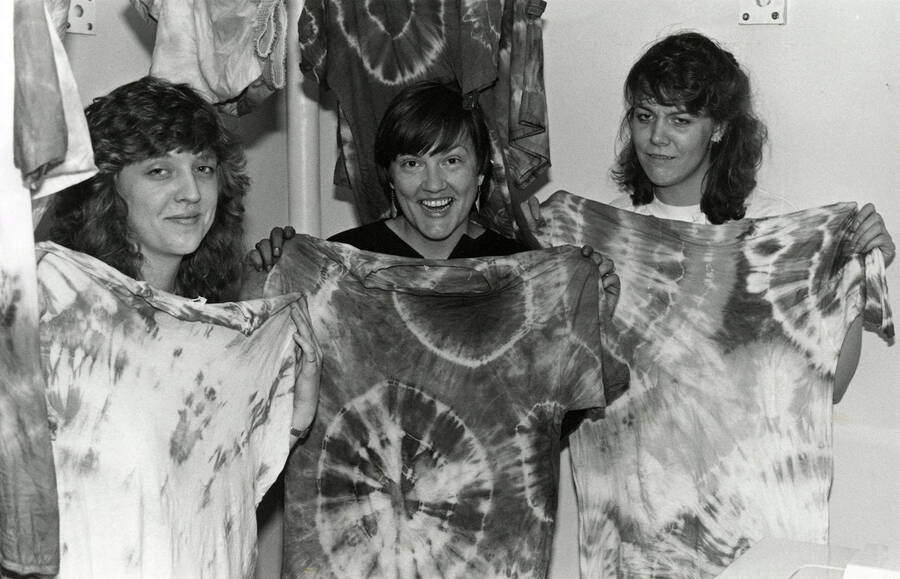 Three students displaying tie-dye shirts.