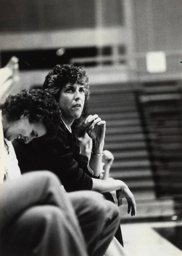 Two women watch a Idaho vs. BSU game (sport unknown) from the sidelines.