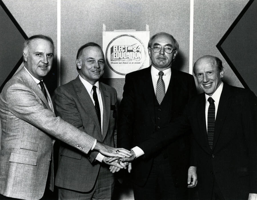 Idaho university and college presidents, with U of I's President Gibb on the far right. The sign behind them reads: ""Elect Education '84 / 'Because the future is in our hands.'""