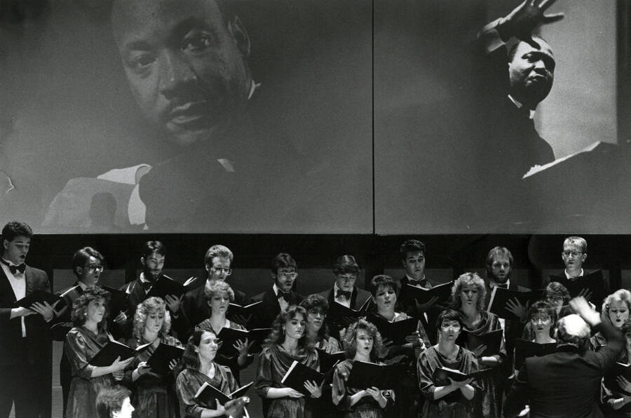 U of I choir performing in front of two large projections of Dr. Martin Luther King, Jr.