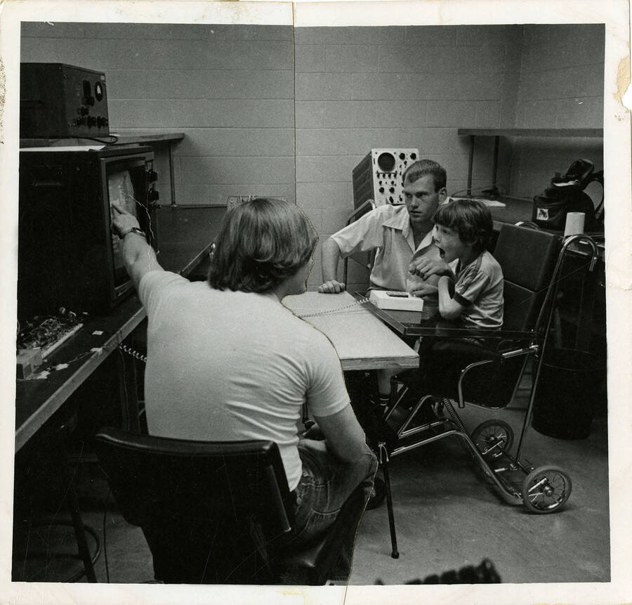 Two men teaching a boy using television. Photo has been manipulated as in carefully cut and pasted together.