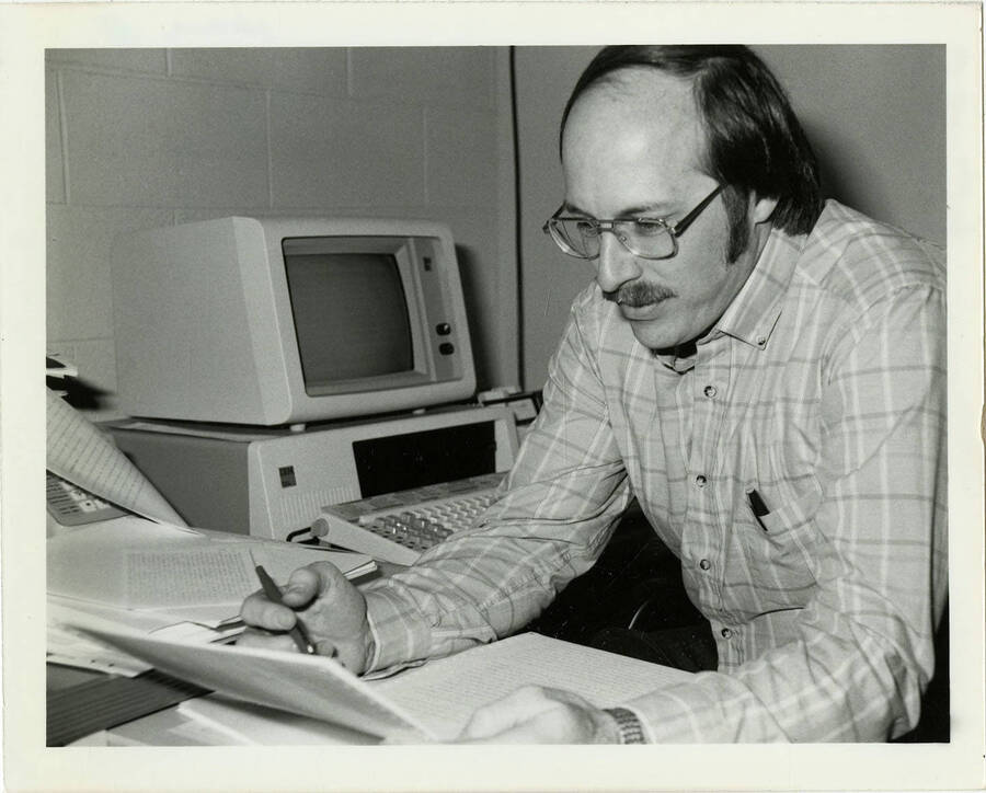 A man (Harris), possibly a professor, grading a paper.