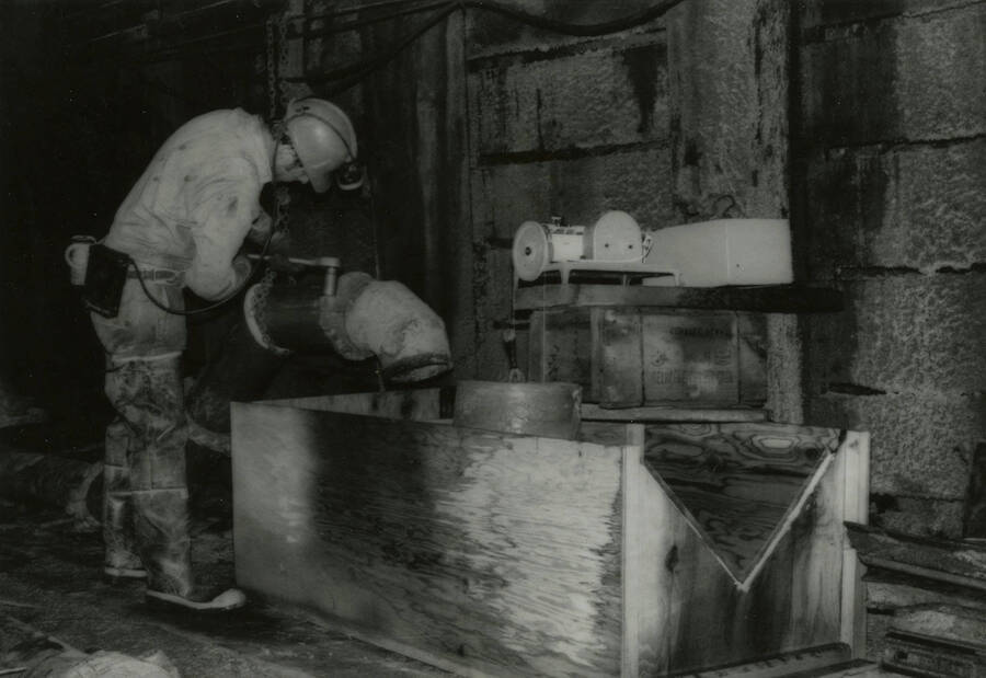 An individual operating mining equipment and wearing protective gear.
