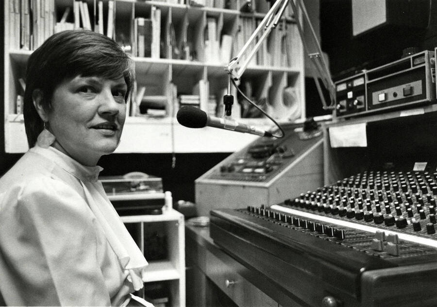 A picture of Betsy Thomas, who was director of the University of Idaho Women's Center from 1985-1997, sitting at a sound board at KRFP Radio. Until her retirement in 2006, she was the job locator and counselor for Student Financial Aid Services at the university. Previously, Thomas provided public relations and fundraising services for the Moscow-Pullman Pregnancy Counseling Service and was a social worker for the Idaho Department of Health and Welfare. She moved from Ohio to Moscow in 1975 and worked as a child protective senior social worker with the Idaho Department of Health and Welfare. A graduate of Ohio State University, Thomas ran twice for the District 5 Idaho House seat. She was active in the National Organization for Women and served as NOW floor organizer at the National Democratic Convention in Los Angeles. She served as president of Idaho NOW and was on the NOW National Board of Directors. Former Gov. Cecil Andrus appointed Thomas to the Martin Luther King Jr. Federal Holiday Task Force and the Idaho Council on Domestic Violence. She was the recipient of the Virginia Wolf Distinguished Service Award by the UI Women's Center, the Rosa Parks Award from the Latah County Human Rights Task Force, and the Athena Woman of the Year Award. (Excerpted from the Moscow-Pullman Daily News obituary, 2007: https://dnews.com/obituaries/obituary-betsy-thomas/article_359f4136-0b22-5538-8bf7-f75aa3db0569.html)