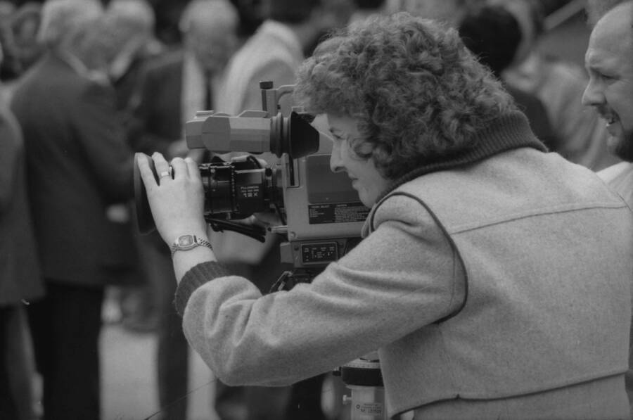 A woman operating a video camera.