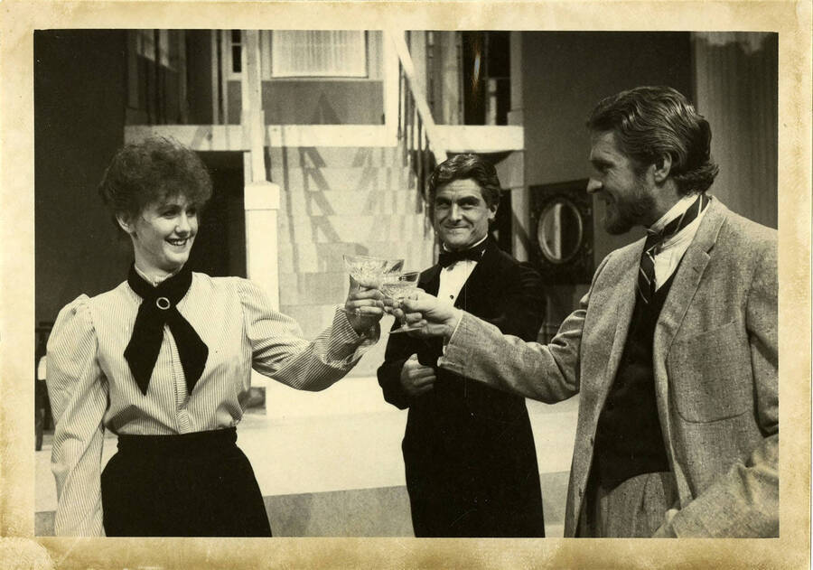 Two men and a woman toasting.