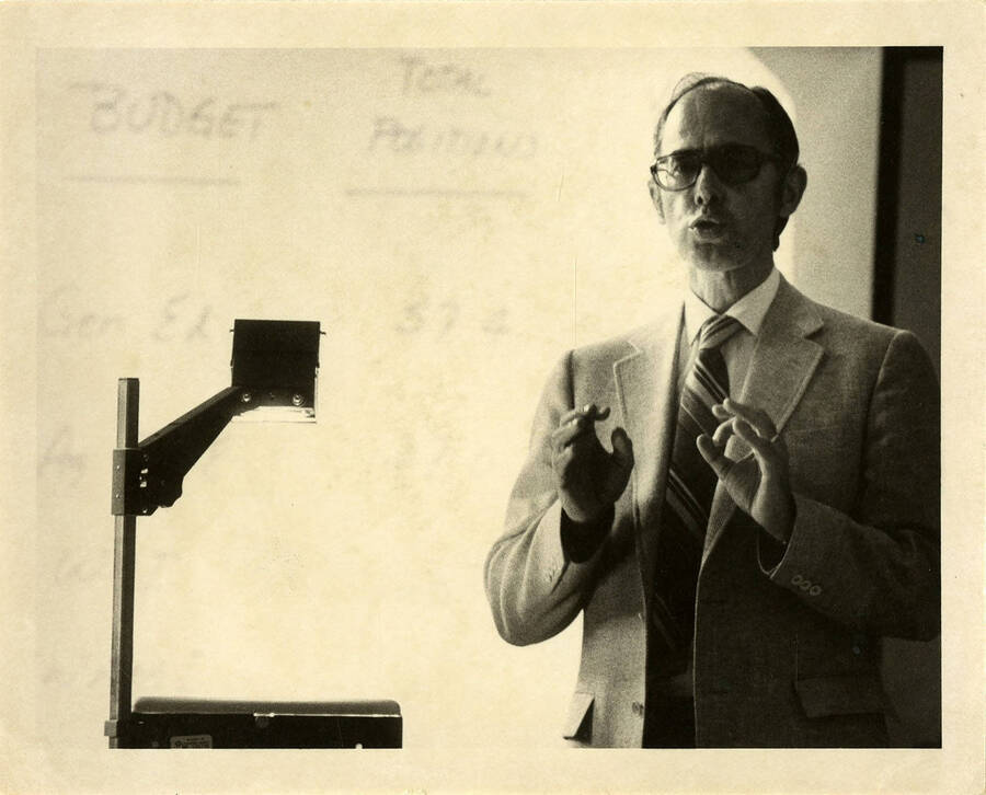 Robert Furgason teaching in front of an overhead projector.