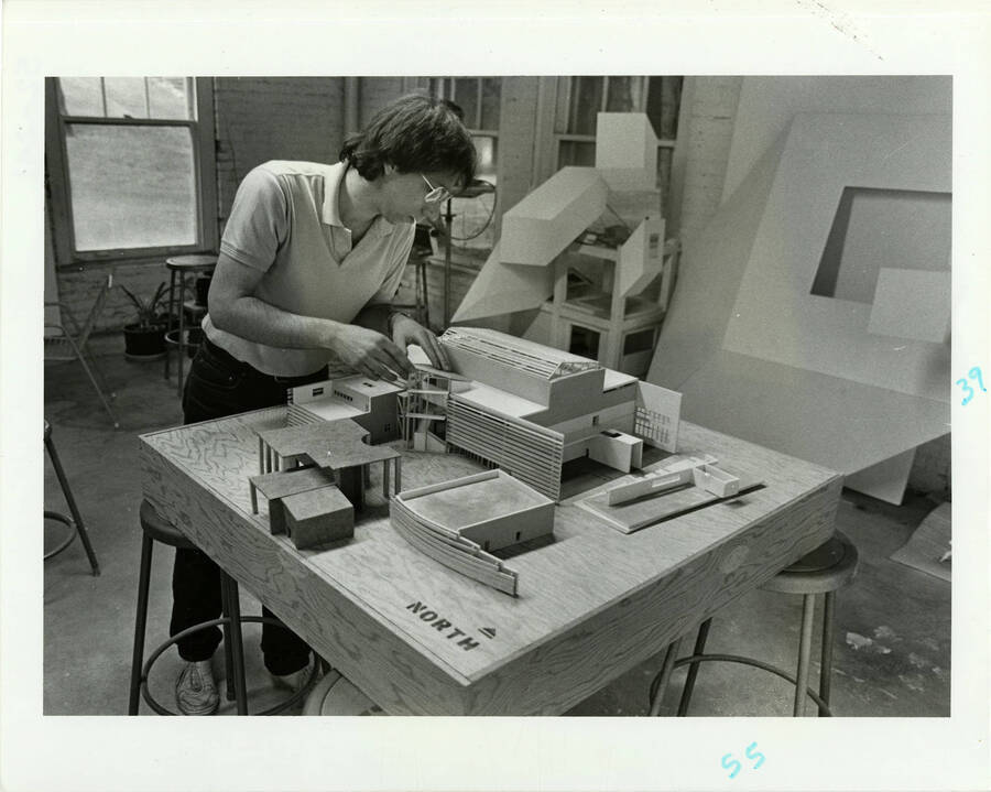 Male student building an architectural model.
