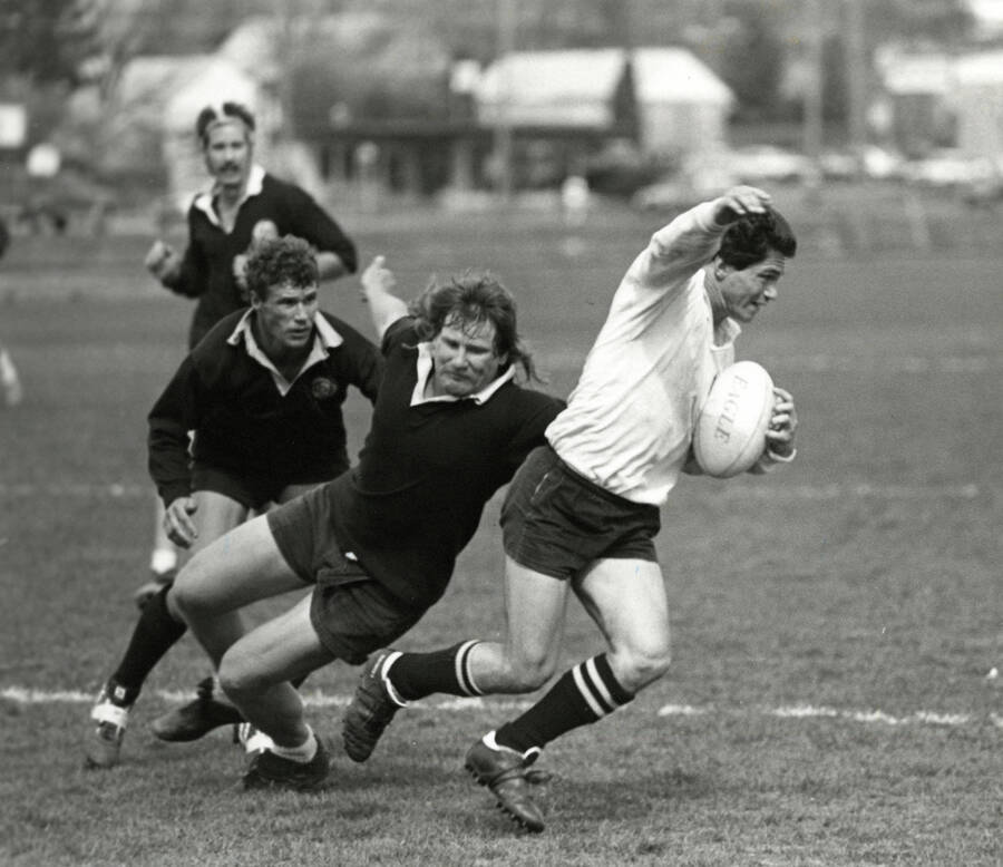 Four men playing rugby.