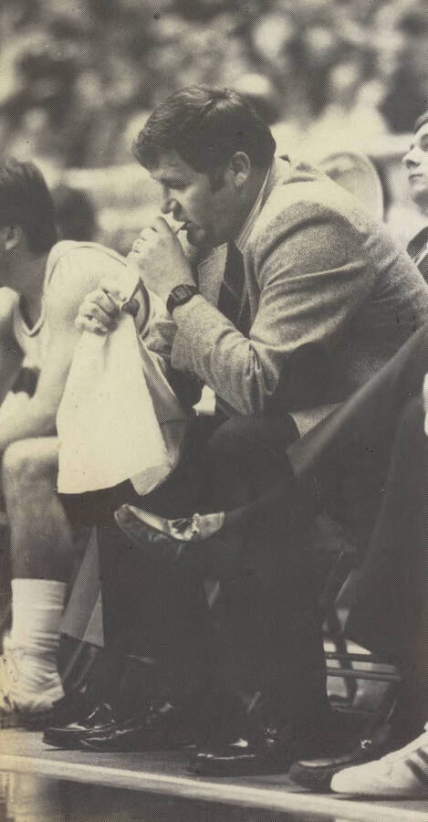 Basketball coach Bill Trumbo chewing a towel on the sidelines.