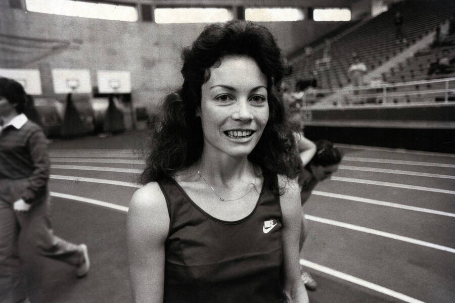 Colleen Williams-Cozzetto posing in front of a track and field course.