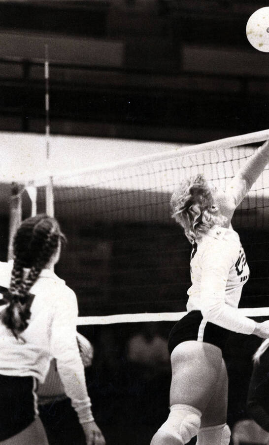 Two students playing volleyball.