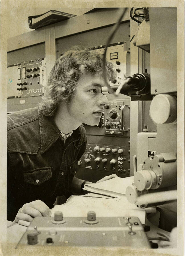 Ken Pavlick looking into equipment, possibly a microscope.