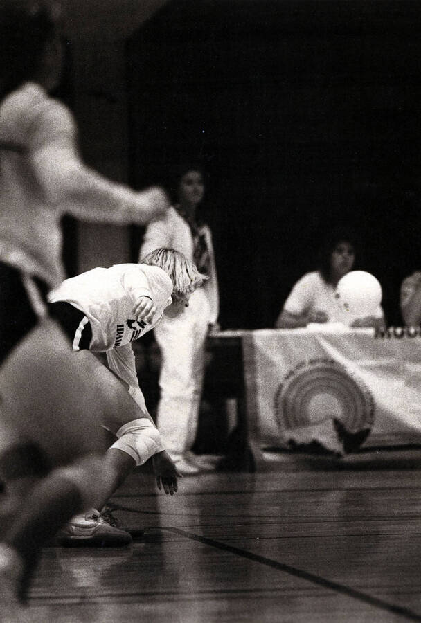 A student going for the ball during a volleyball game.