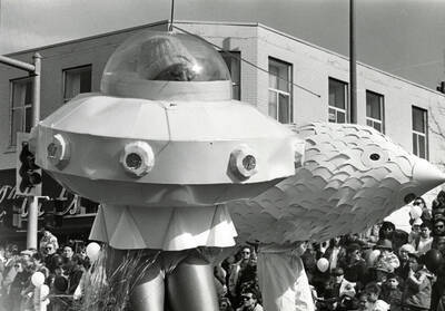 Two people in costumes during a Mardi Gras parade on the corner of Main Street and 3rd.