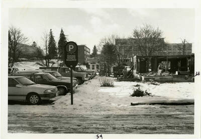 Demolition of a house near the Buchanan Engineering Building and university parking lot. Note the snow on the ground and the workers in the demolished house.