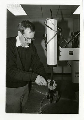 Man working with IBM 7545 Manufacturing System Robot.