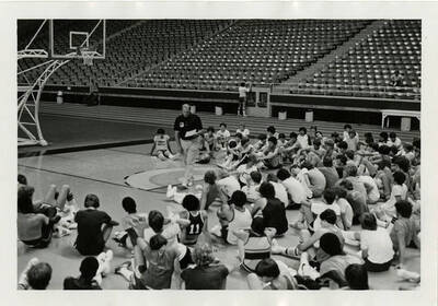 Don Monson talking to basketball players at summer basketball camp.