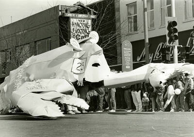A white lobster parade float with the number 23 on its side moves through a parade on Main Street, on the north side of the 3rd Street and Main Street intersection.
