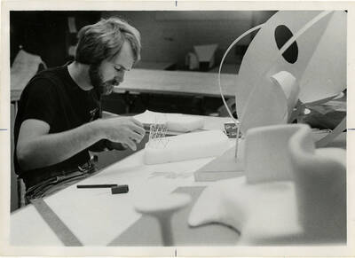 Student building an architectural model out of toothpicks and styrofoam.