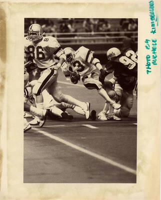 Vandal football player tackling the opposing team member.