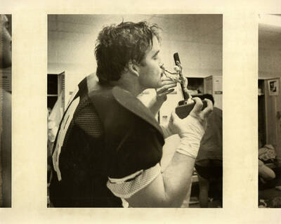 Football player kissing trophy.