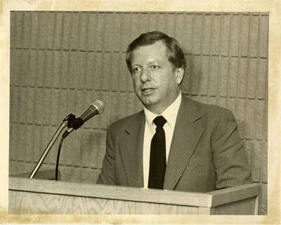 VP of Finance David McKinney giving a speech at a podium with a microphone.