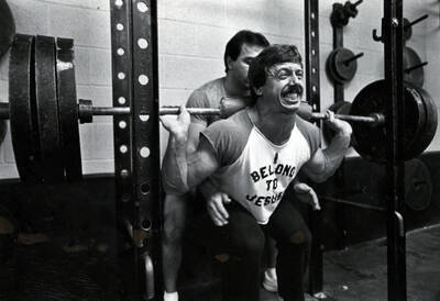 Students lifting weights in weight room.