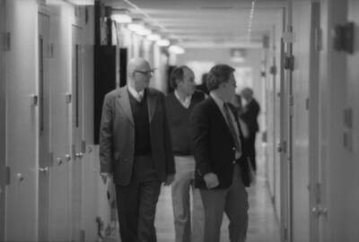 A group of people walking through a hallway.