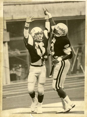 Idaho football players cheering and giving high-fives.