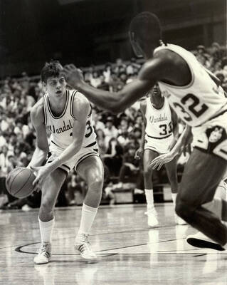 Three Vandals basketball players moving the ball during a game.