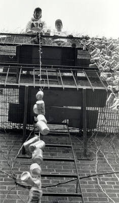 Students hanging beer cans from the Alpha Tau Omega house.
