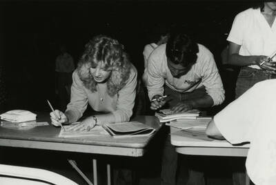 Two students registering for their classes in the Kibbie Dome.