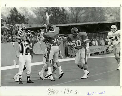 Broncos football team cheering while the referee makes a call.