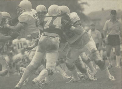 Cluster of football players defending the ball.