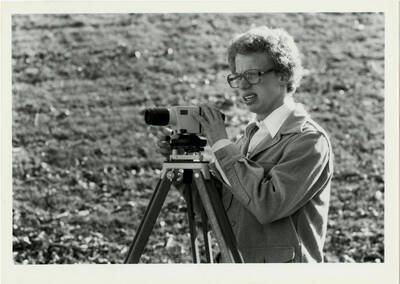Man with surveyors equipment looking confused.