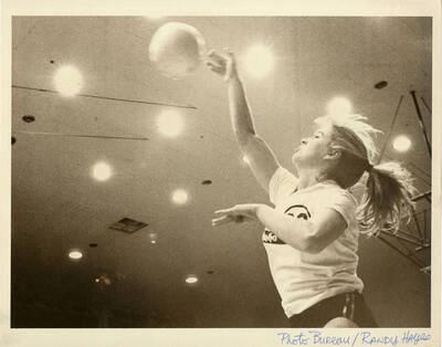 Volleyball player, possibly Robin Resheck, hitting the volleyball in the air.