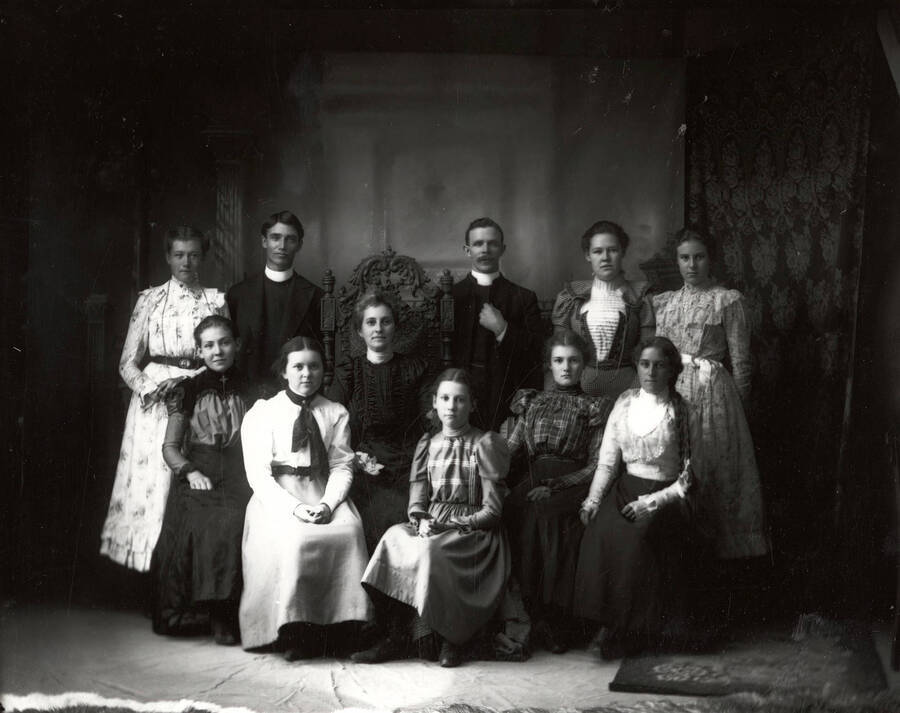 The girls of the Holy Trinity Episcopal Church girls group; of Wallace, Idaho; posing with two priests.