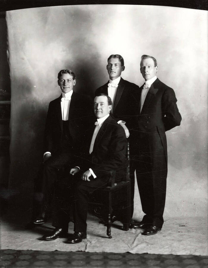 Four men, who are part of a vocal quartet, posing together.