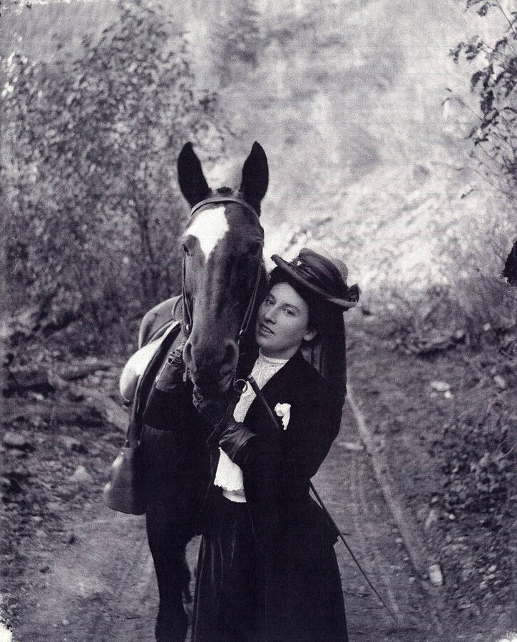 Mrs. A. Johnson standing with a horse.