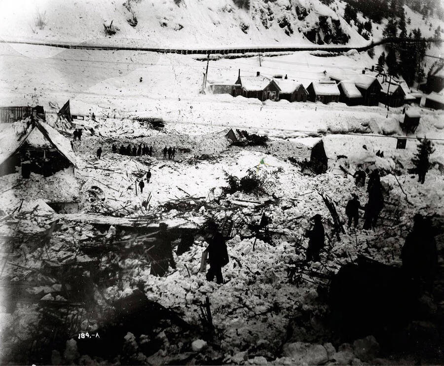 Image shows people shoveling out amongst the debris of a snow slide that occurred on February 27 of 1910, in Mace, Idaho.